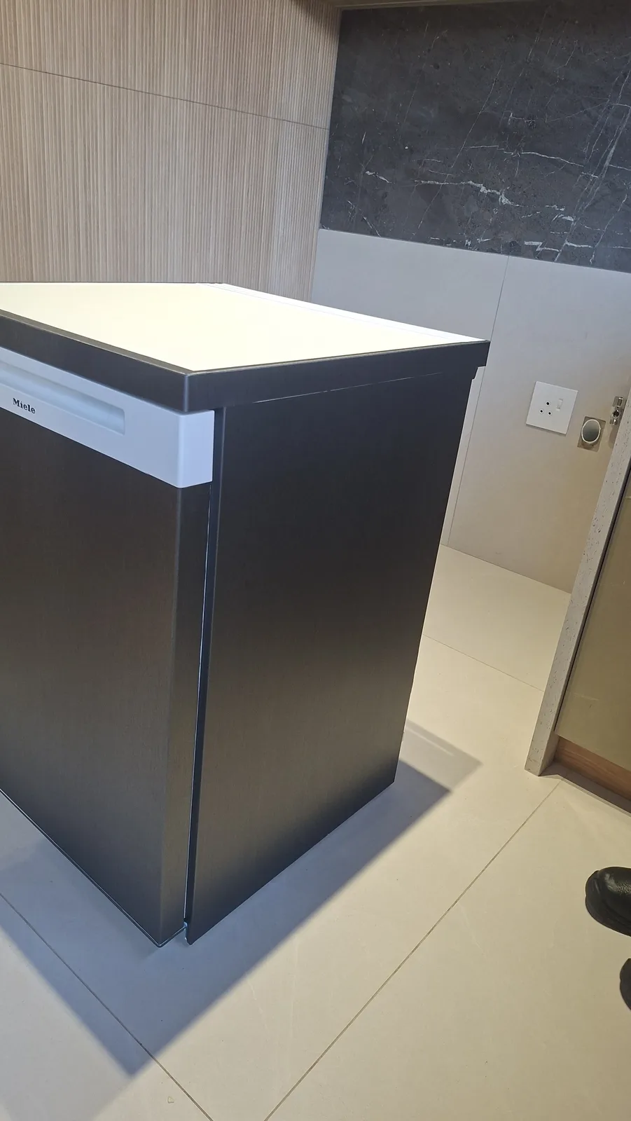 Built-in kitchen appliance wrapped in charcoal wood-grain architectural film